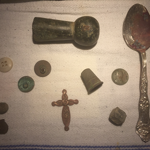 Assorted relics (hames top, thimble, brass cross, flat buttons, musket balls etc).