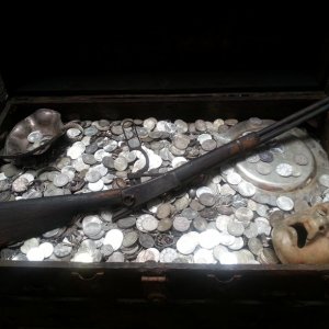 Treasure artifacts like an old riffle, silver plates and a ceramic mask.