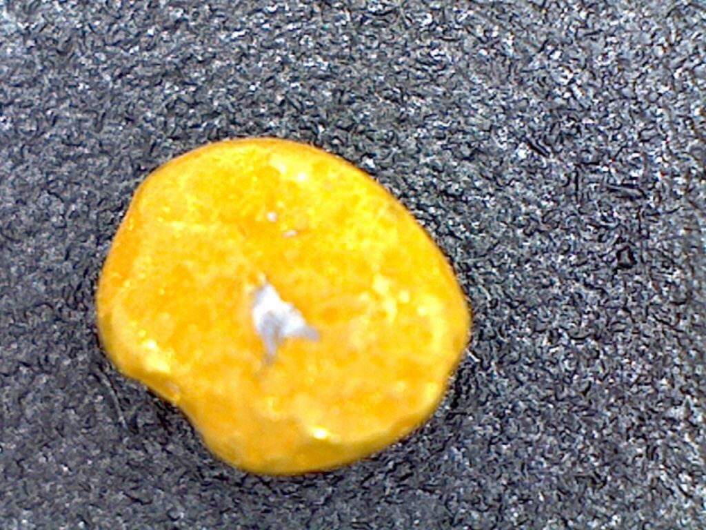 Odd piece of coarse gold magnified with high power lighting