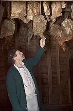 hams hanging from SMOKEHOUSE.webp