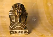 11590288-Small-statue-of-egyptian-pharaoh-Tutankhamun-front-view-over-a-papyrus-paper-backgro...webp