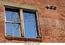 window-frame-and-electrical-insulators-remain-on-brick-building-wall-ctn7m4.webp