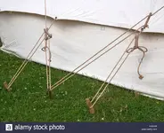old-style-canvas-tent-showing-rope-guy-lines-and-carved-wooden-tent-E3J4M2.webp