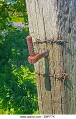 an-old-weathered-wood-gate-post-with-a-rust-pintle-pin-d9pf7k.webp