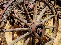 wooden-wagon-wheel-axle-weathered-rusted-rustic-western-spoke-hub-stands-sunlight-background-...webp