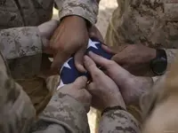 stk102498m~Marines-Fold-an-American-Flag-after-It-was-Raised-in-Memory-of-a-Fallen-Soldier-Po...webp