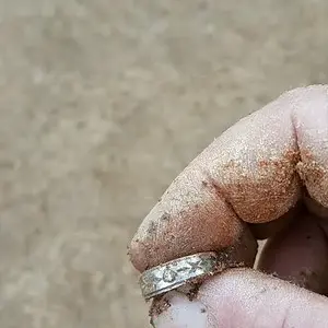 12k white gold with a small diamond on it.