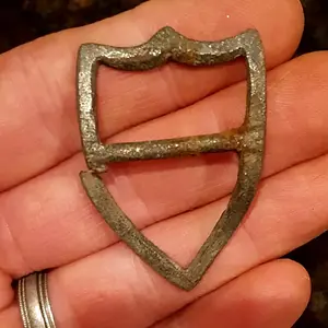 Shield-shaped harness buckle