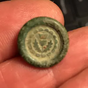 Front of small button.