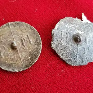 Two pewter coat buttons with raised letters "PN" on the back.  These were likely worn by American troops during the Revolutionary War.
