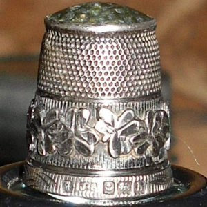 English Silver Thimble - 1907 - This sterling silver thimble was manufactured by James Swann. It features a green agate stone top with a dimpled main 