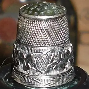 English Silver Thimble - 1907 - This sterling silver thimble was manufactured by James Swann. It features a green agate stone top with a dimpled main 