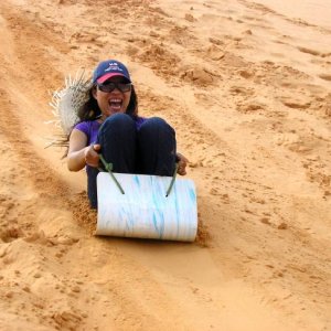 girl going down the sand dunes in mui ne