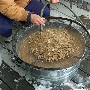 Classifying the sand and rocks with a fire screen into a washtub and then the cons are returned to the bucket