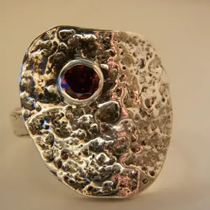 Close up of abstract sterling silver and garnet ring