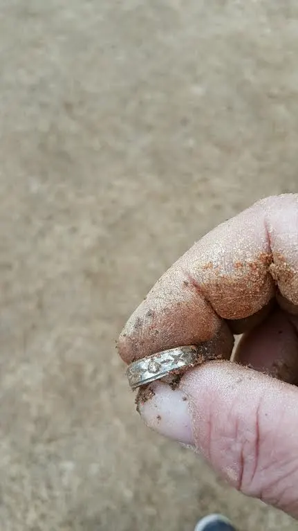 12k white gold with a small diamond on it.