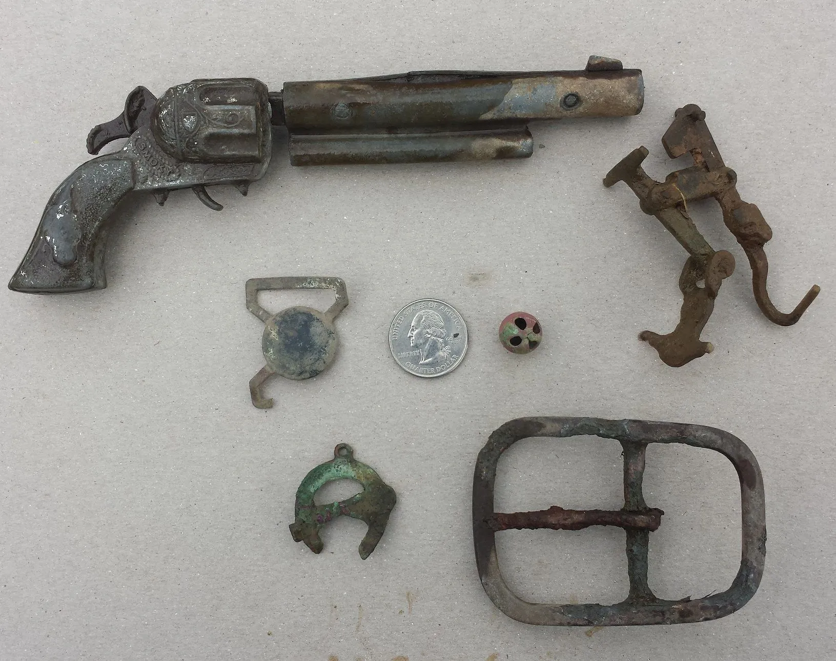 20150927 A collection of relics found on private property in Madison. Included are a 1950s era toy pistol, a suspender buckle, a large buckle and a sm