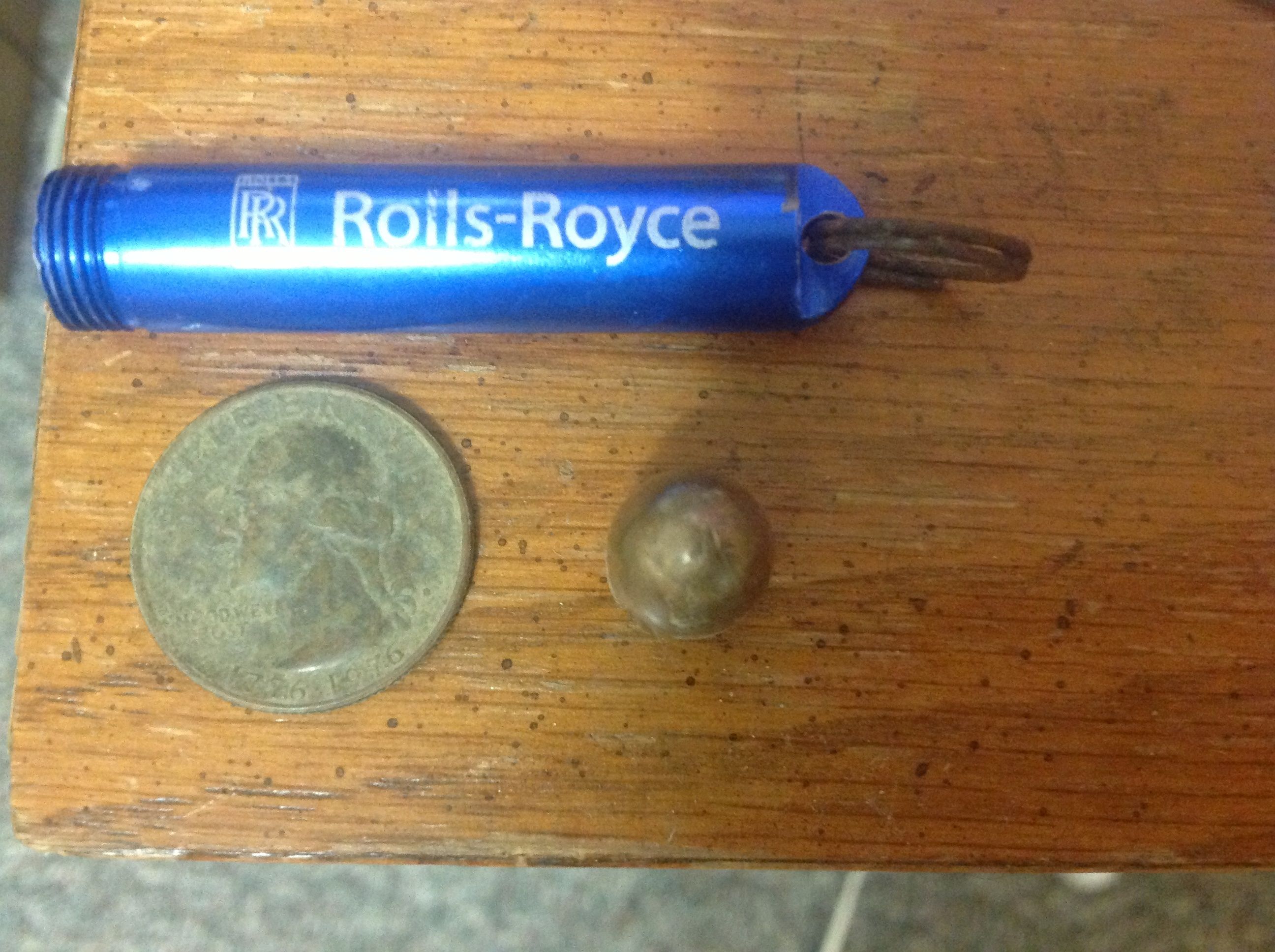 A Bicentennial quarter, 45 ACP projectile and a rolls Royce thingy