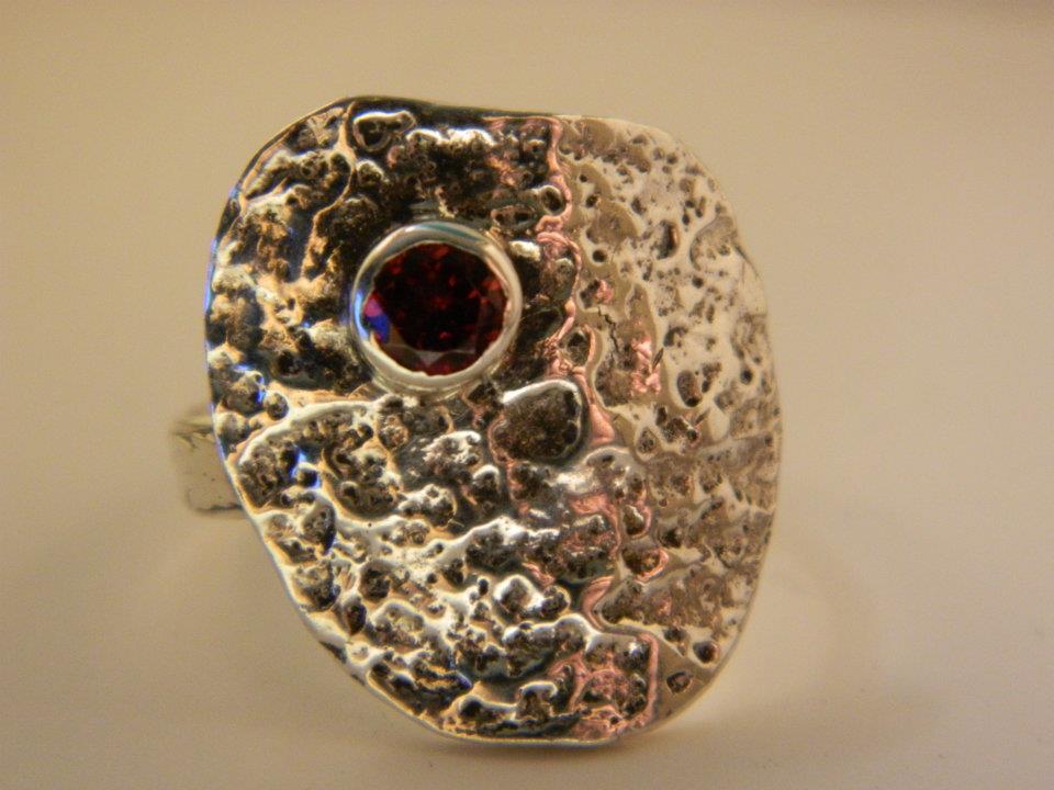 Close up of abstract sterling silver and garnet ring