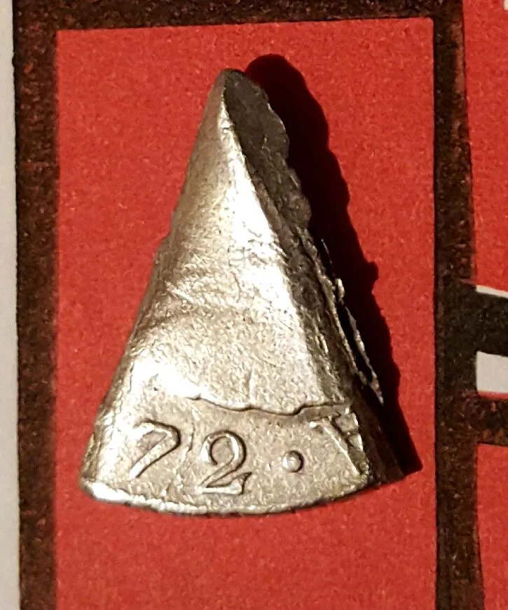 Cut 1772 Spanish eight reales silver coin.  This piece is one eighth of the original coin and would have been worth one real. Also referred to as a "b