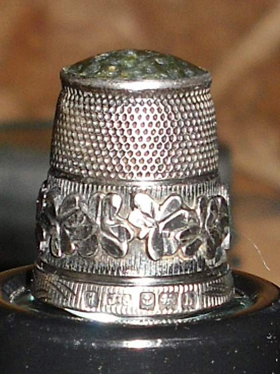English Silver Thimble - 1907 - This sterling silver thimble was manufactured by James Swann. It features a green agate stone top with a dimpled main 