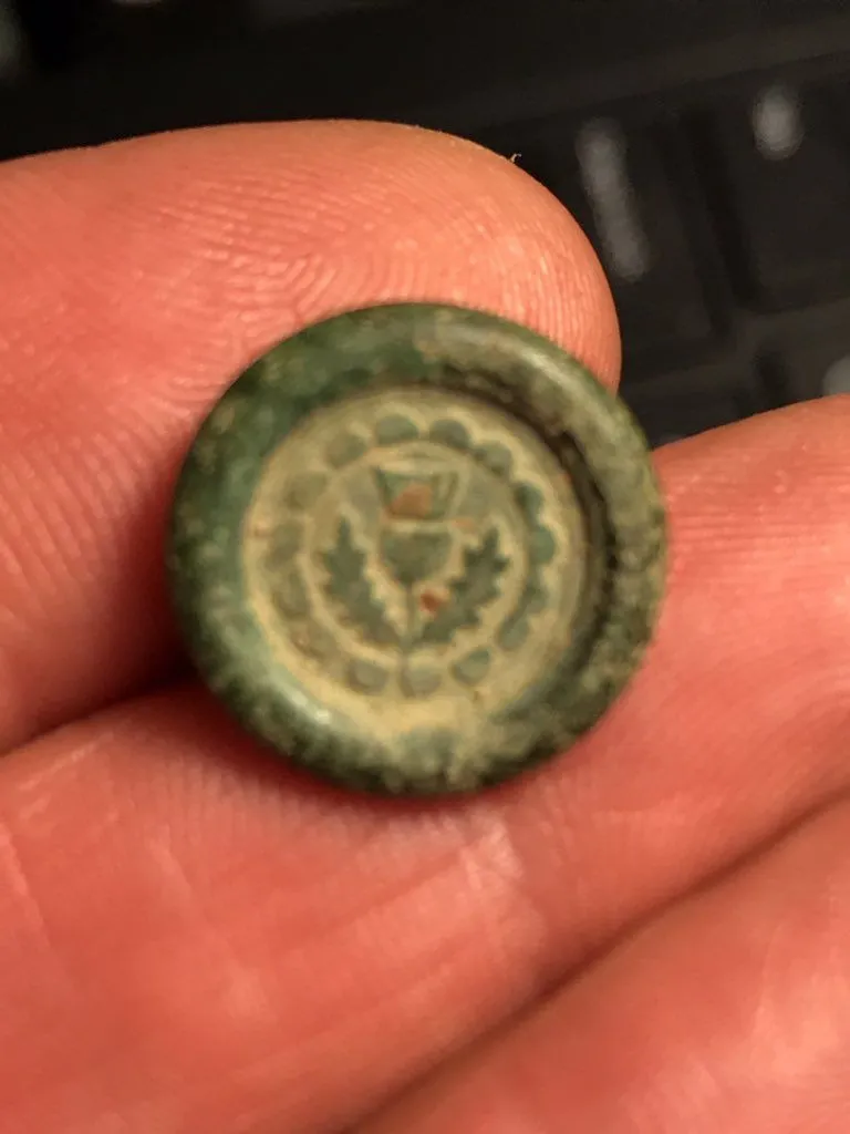 Front of small button.