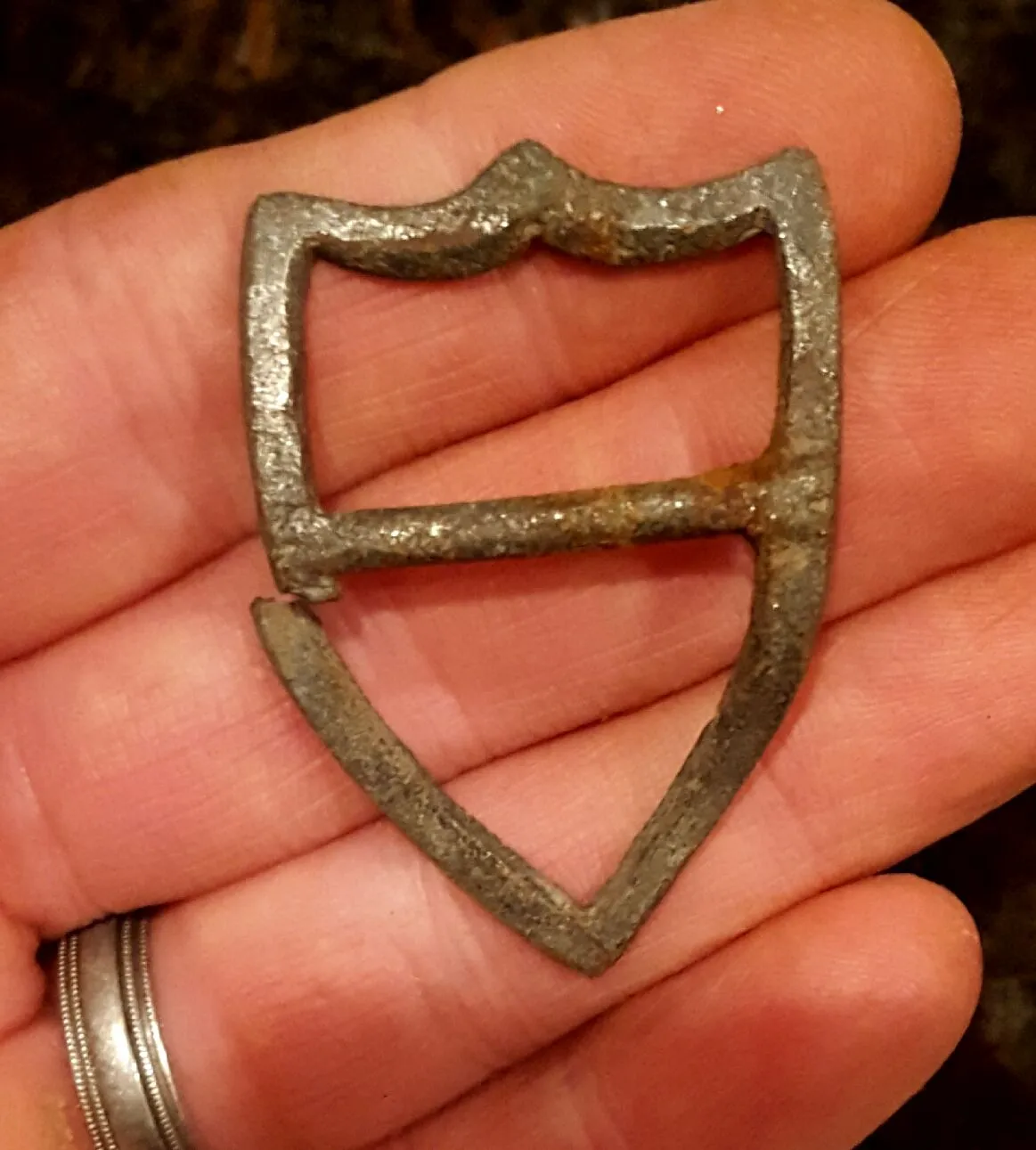 Shield-shaped harness buckle